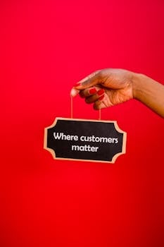 A hand holding a sign with the text 'Where customers matter' against a red background.