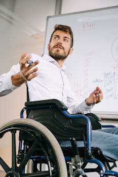 Confident business professional in wheelchair presenting ideas in office setting.
