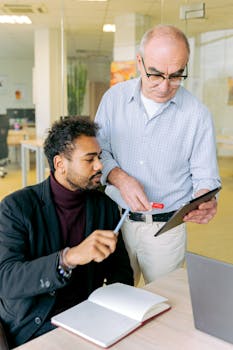 Two colleagues having a productive discussion in a modern office setting.